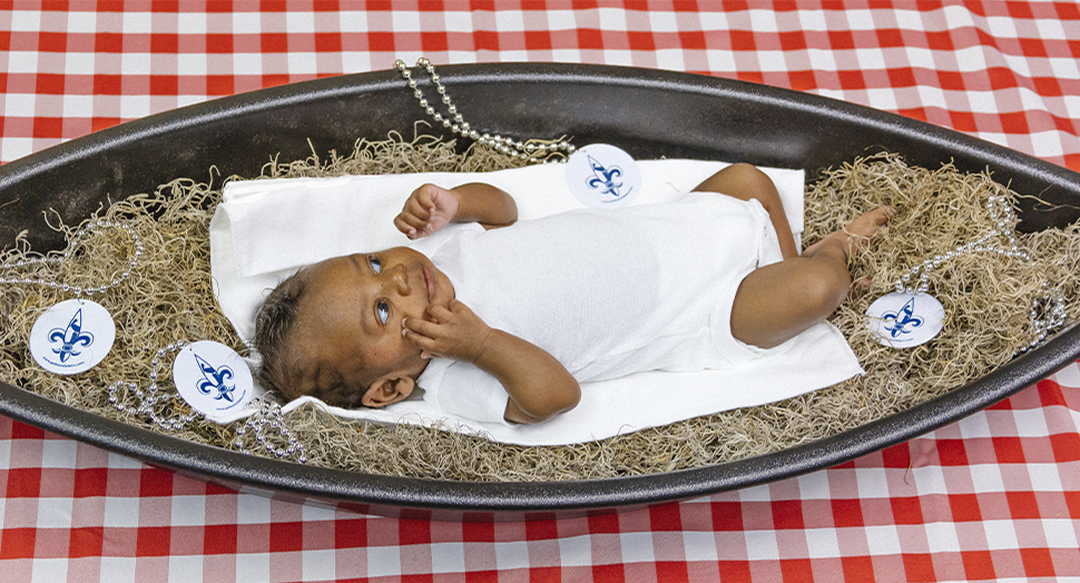 Baby in a Louisiana Pirogue surrounded by Louisiana moss and beads