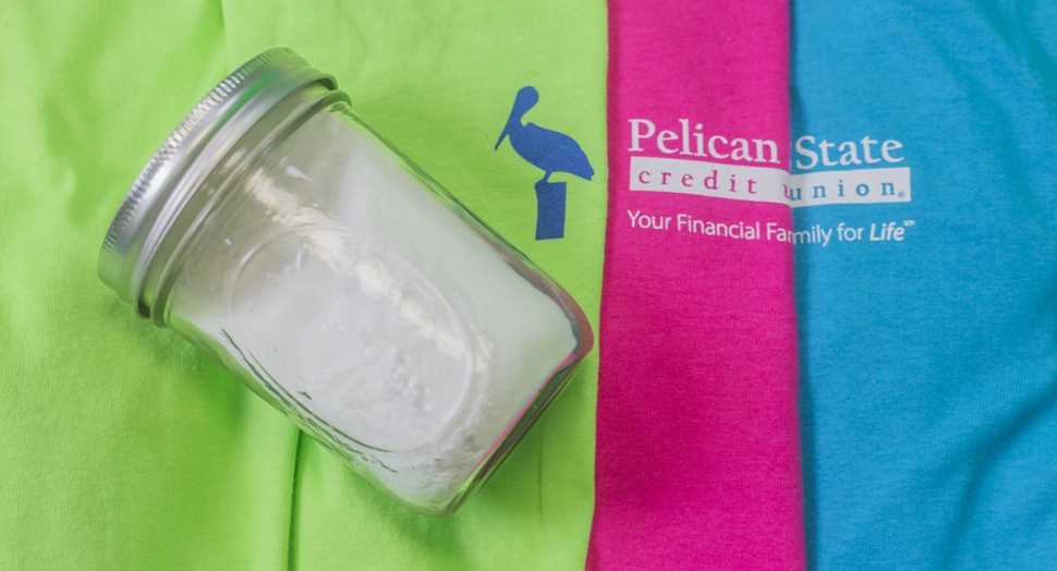 Homemade Laundry Detergent in a jar on some freshly-cleaned t-shirts